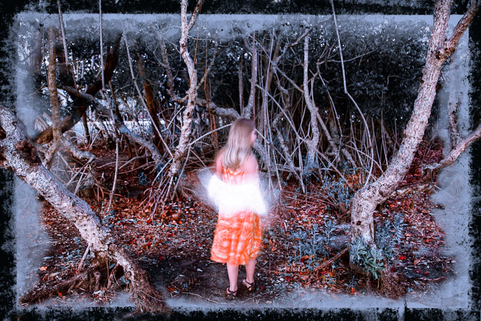 Figure in an orange dress standing among mangroves